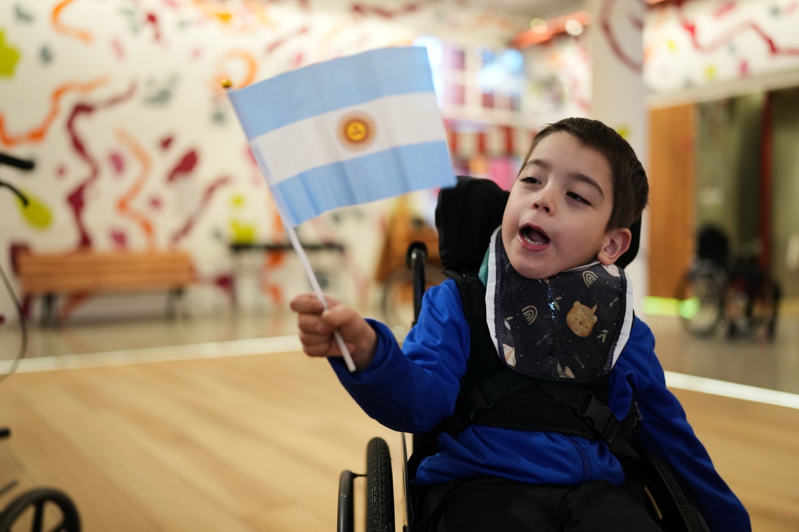 Niño de AEDIN saludando con una bandera argentina